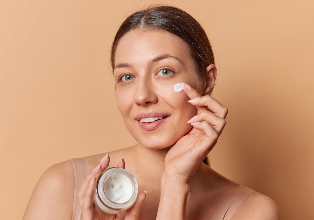 Una chica echando crema en la cara. Imagen que representa la cosmética facial.