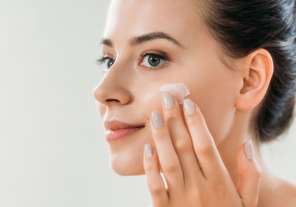 Una chica echando crema en la cara. Imagen que representa la cosmética.