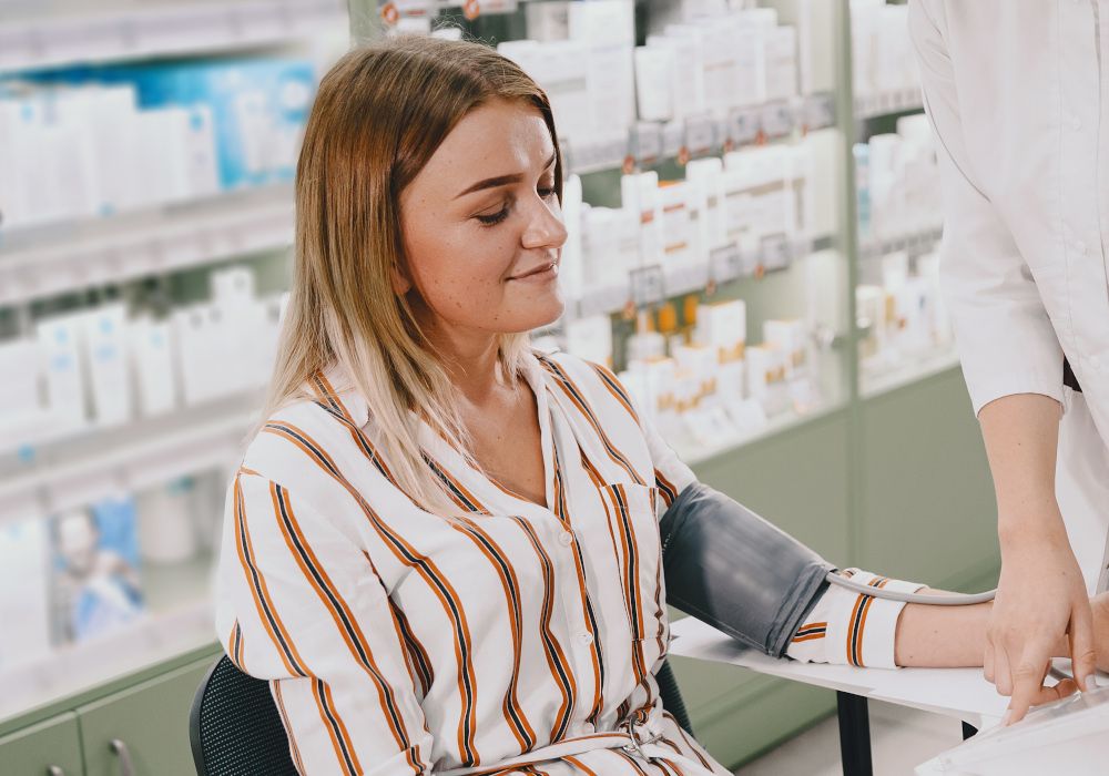 Una chica tomándose la tensión en la farmacia.